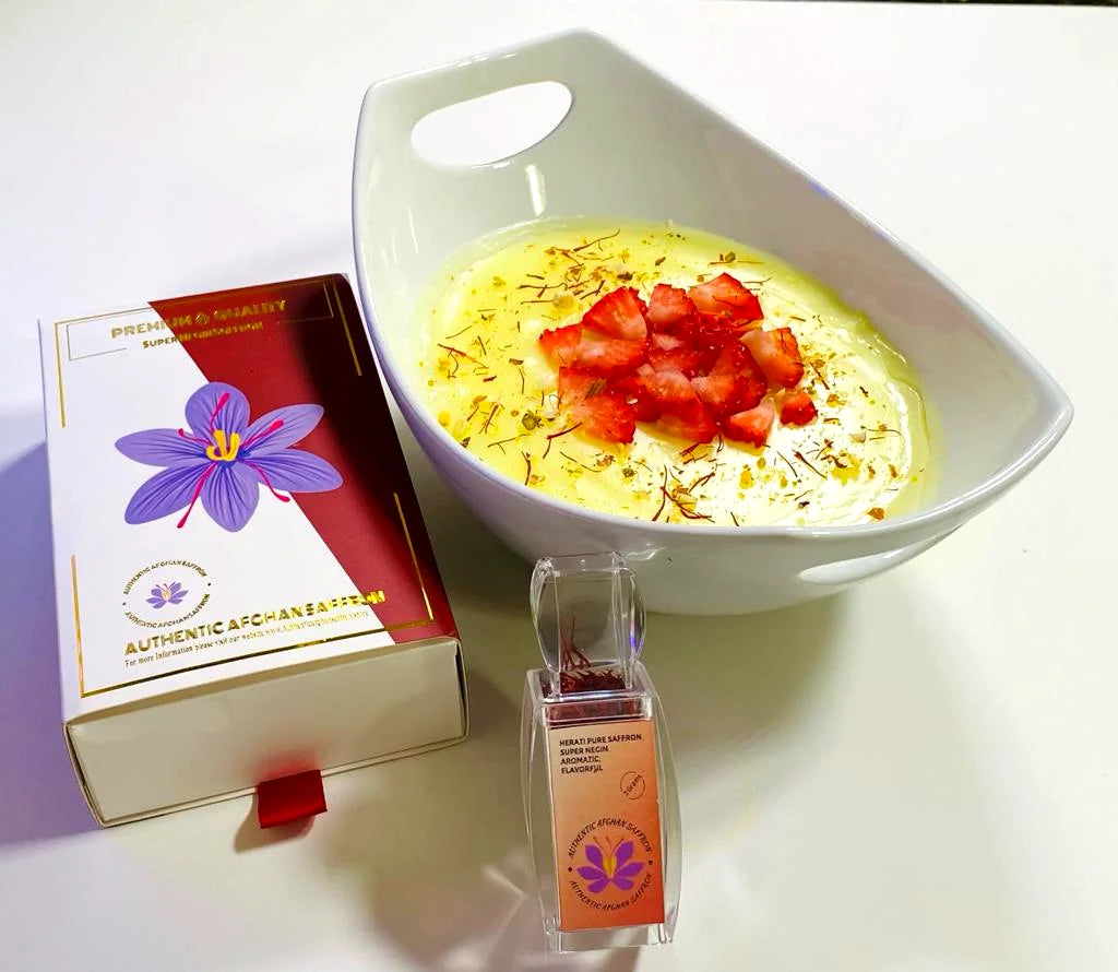 The Authentic Afghan Saffron gift box beside a bowl of saffron firni topped with strawberries and red saffron threads
