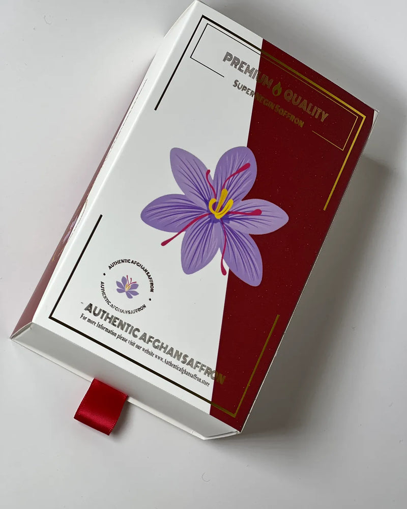 The Authentic Afghan Saffron gift box in cream and burgundy with a gold-foiled crocus, holding two 1g crystal bottles